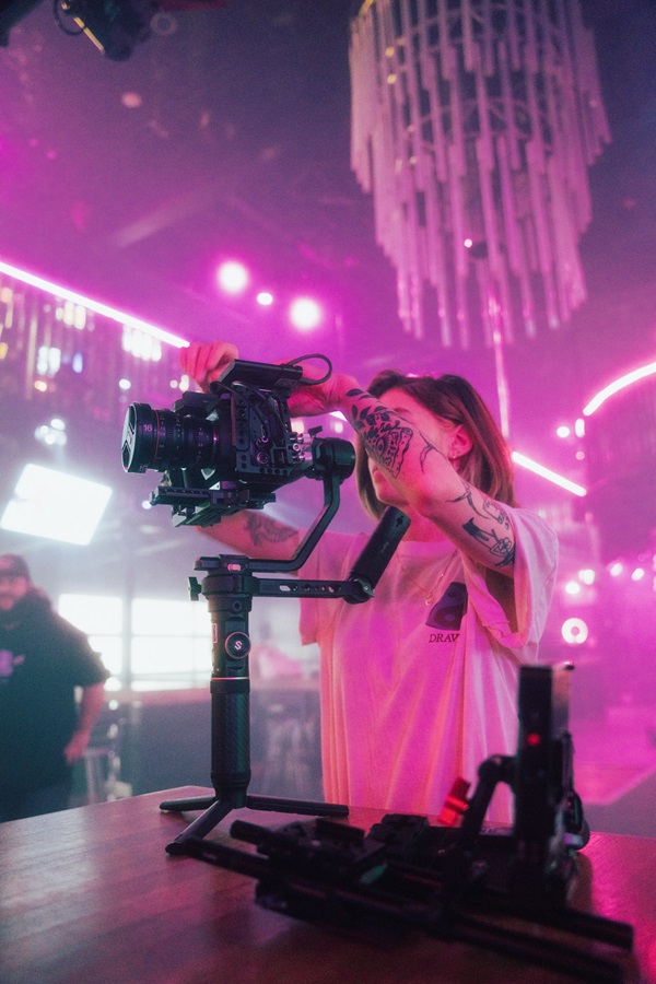 A woman films a music video in a club.