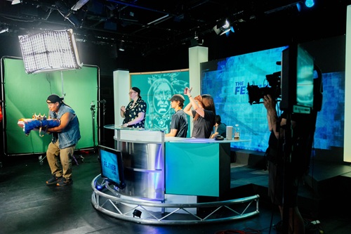 A newsroom scene featuring actors