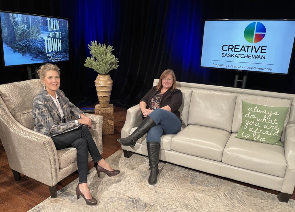 Creative Sasaktchewan's CEO is seated on a white leather couch being interview by the media outlet host Lisa Peters from Talk of the Town.