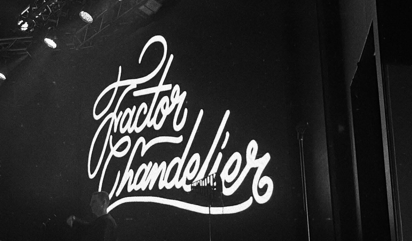 A black and white photo of a concert stage. The backdrop reads 